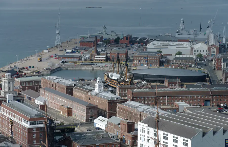 Portsmouth Historic Dockyard from above, red-brick naval storehouses around HMS Victory in dry dock